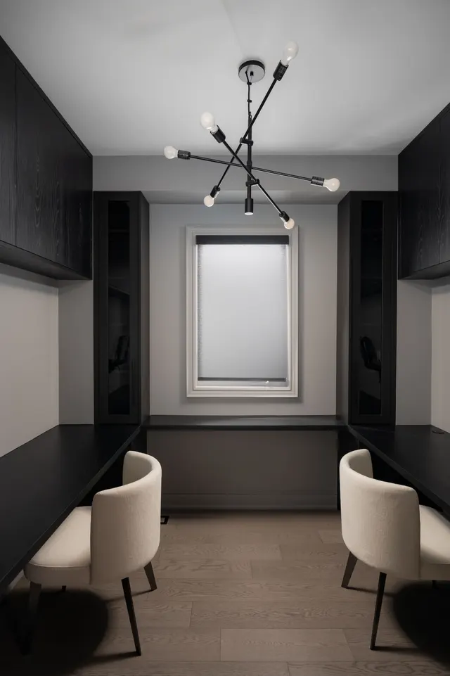 Narrow dining nook between charcoal built-ins under a sputnik chandelier