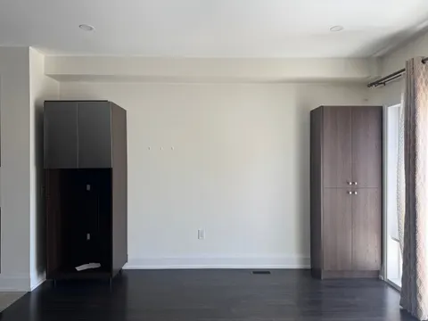 The pantry wall before the work: two freestanding cabinets on the dark floor that stayed
