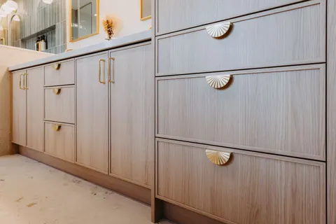 Close view of the oak shaker drawers and their scalloped brass pulls