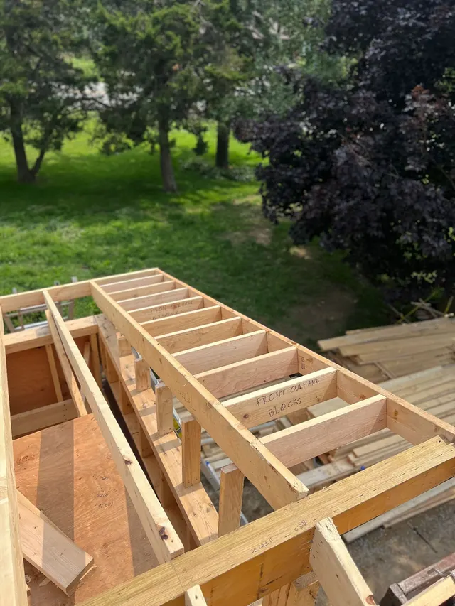 Looking down into the framed addition: new walls and floor joists in fresh lumber